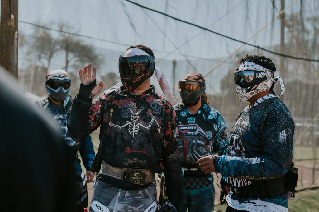 Joueurs de paintball masqués qui préparent leur stratégie