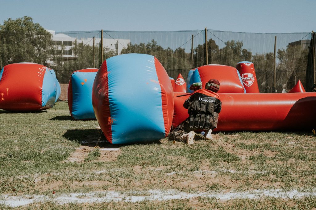 Joueur accroupi derrière un obstacle gonflable de paintball